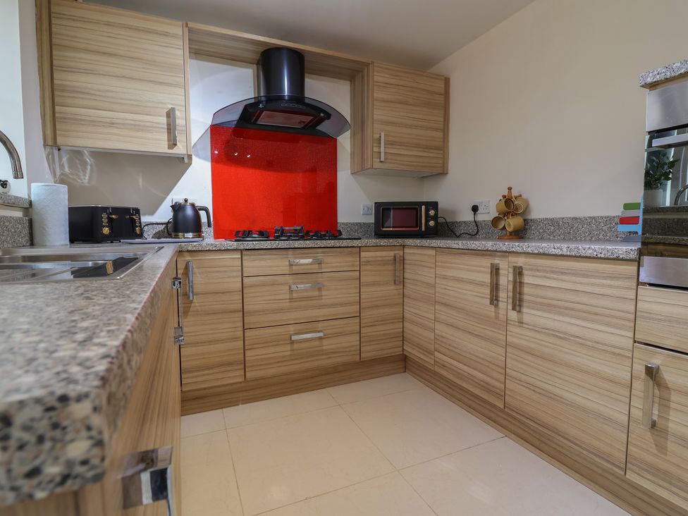 A kitchen with cabinets, countertop, sink, and stove at 31 Llys Ogwen in Prestatyn