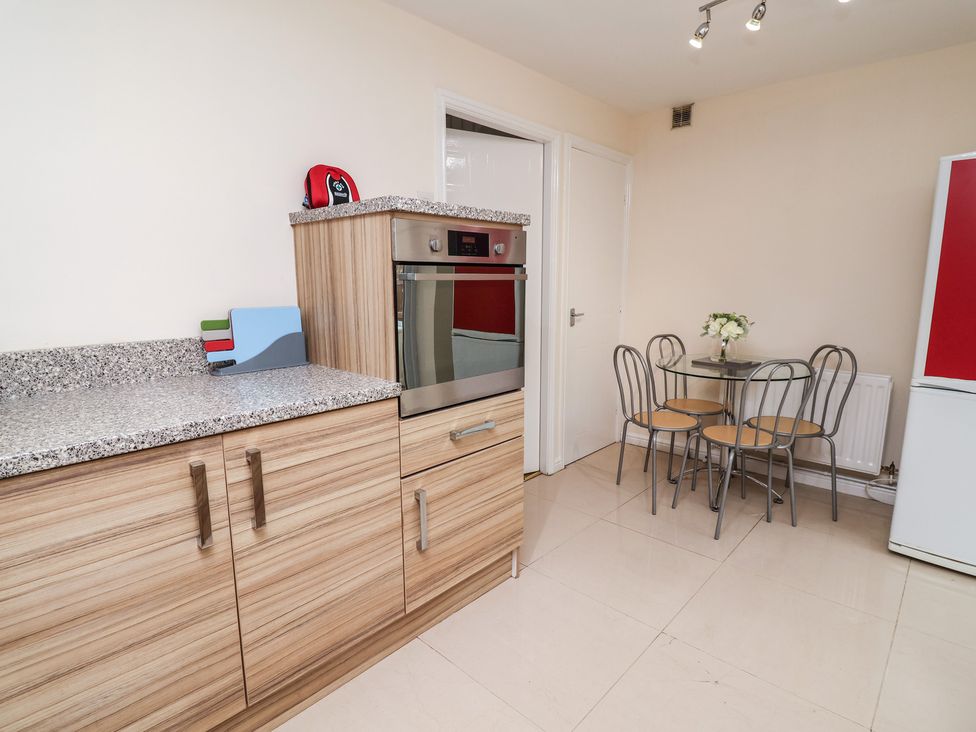 A kitchen with an oven and table in 31 Llys Ogwen Prestatyn