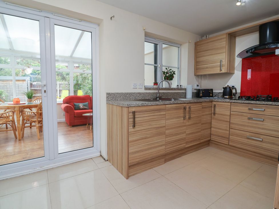 A kitchen with wooden cabinets and sink at 31 Llys Ogwen in Prestatyn