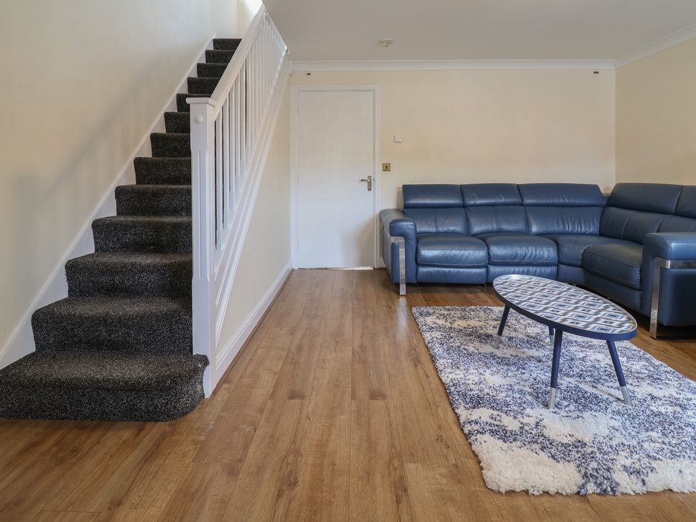 A living room with a blue sofa and coffee table at 31 Llys Ogwen in Prestatyn