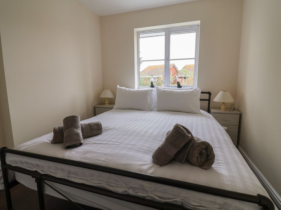 A bedroom with a bed and nightstand at 31 Llys Ogwen Prestatyn