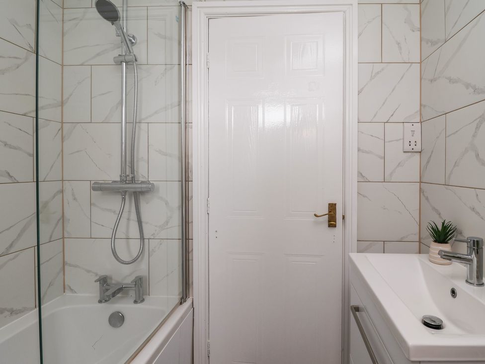 A bathroom with a shower and bathtub at 31 Llys Ogwen in Prestatyn