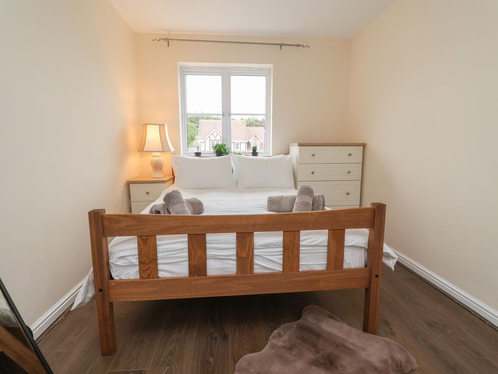 A bedroom with a bed and dresser at 31 Llys Ogwen in Prestatyn