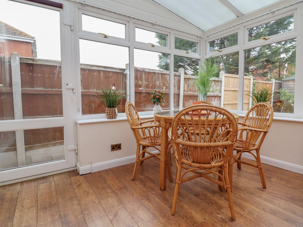 A conservatory with a table and chairs at 31 Llys Ogwen Prestatyn