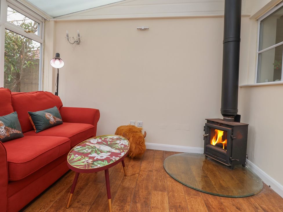 A snug with a sofa and fireplace at 31 Llys Ogwen Prestatyn