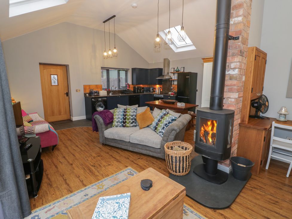 A living room with a fireplace and sofa at Otter's Rest in Droitwich
