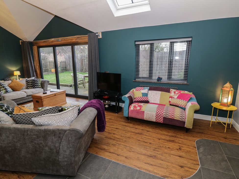 A living room with a sofa and a coffee table at Otter's Rest in Droitwich