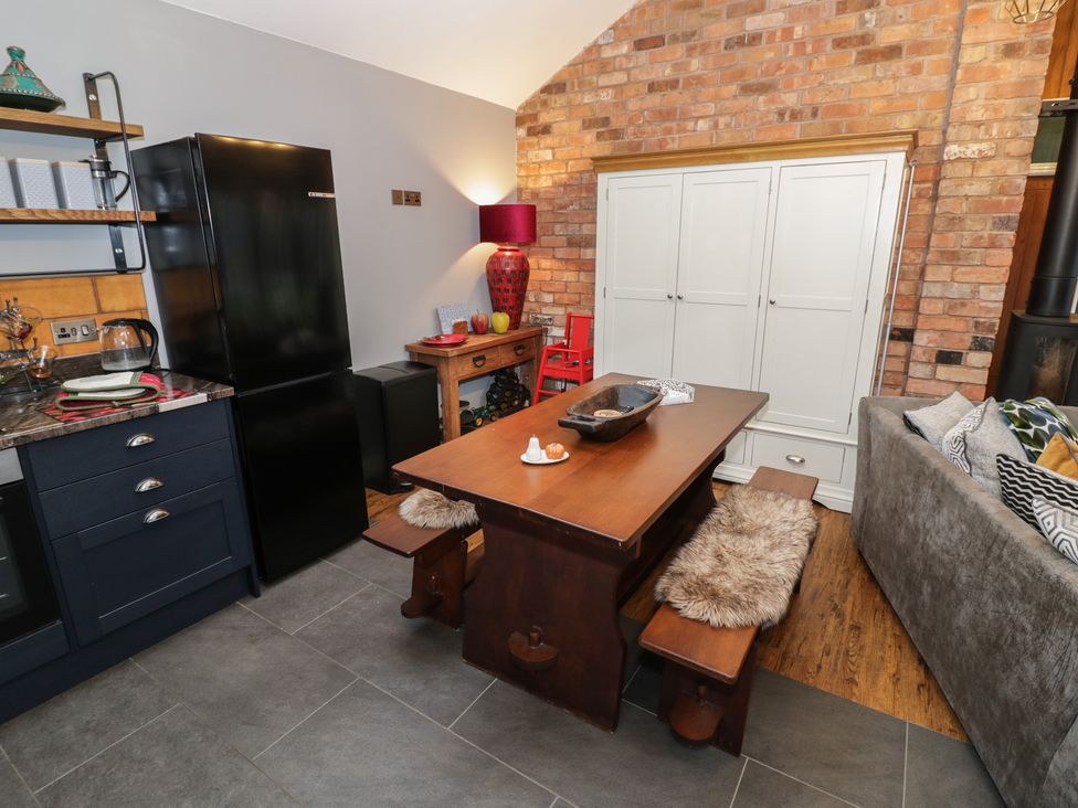 A kitchen with a refrigerator and dining table at Otter's Rest in Droitwich