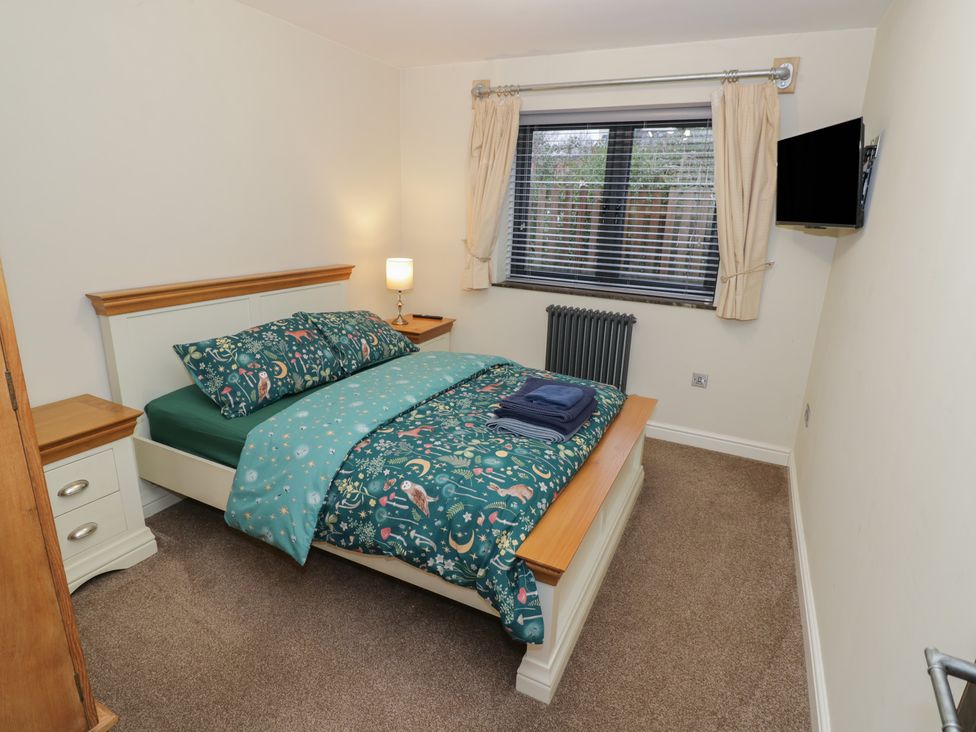A bedroom with a bed, dresser, and television at Otter's Rest in Droitwich