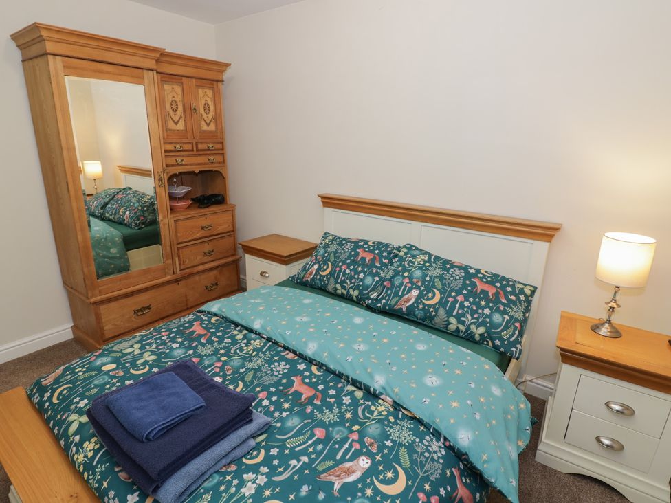 A bedroom with a bed and wardrobe at Otter's Rest in Droitwich