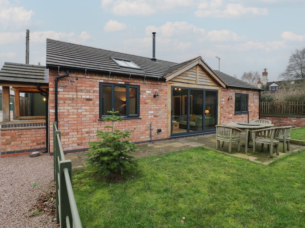 A house exterior with table and chairs in the garden at Otter's Rest in Droitwich