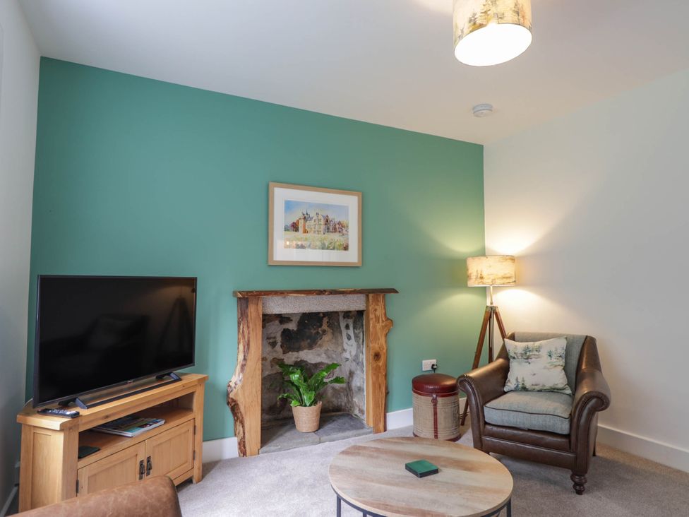 A living room with a television and fireplace at Station Lodge near Forres