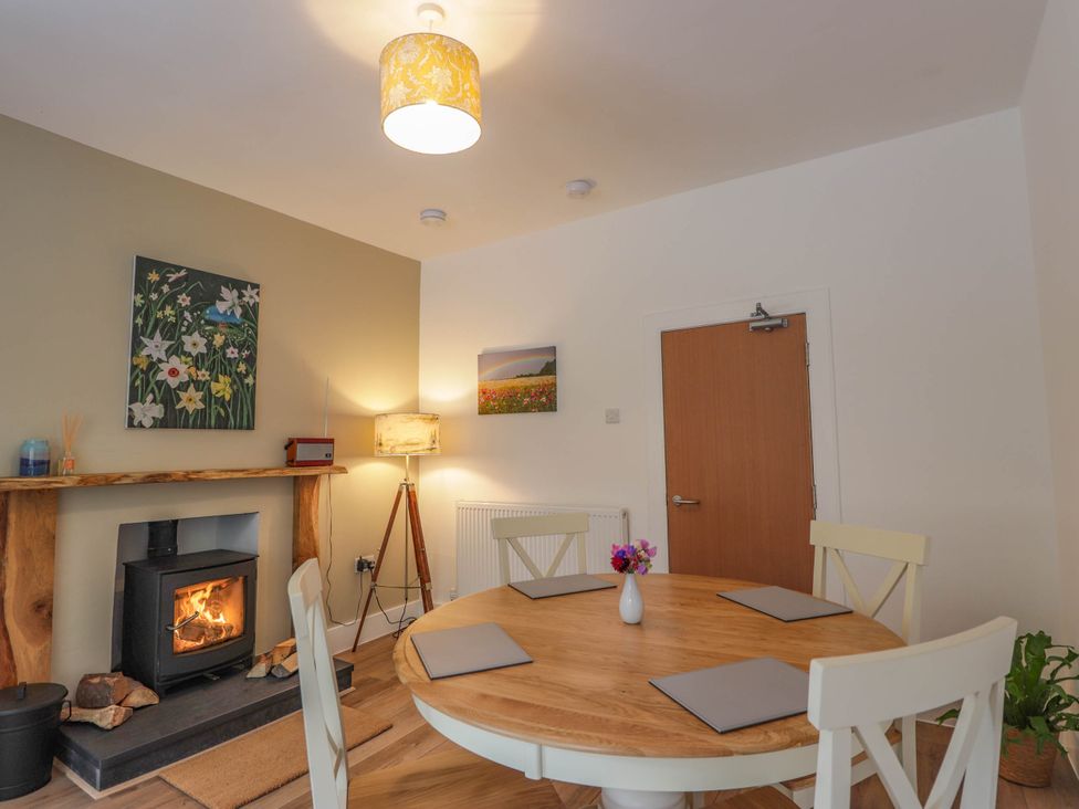 A dining room with a round table and a fireplace at Station Lodge near Forres