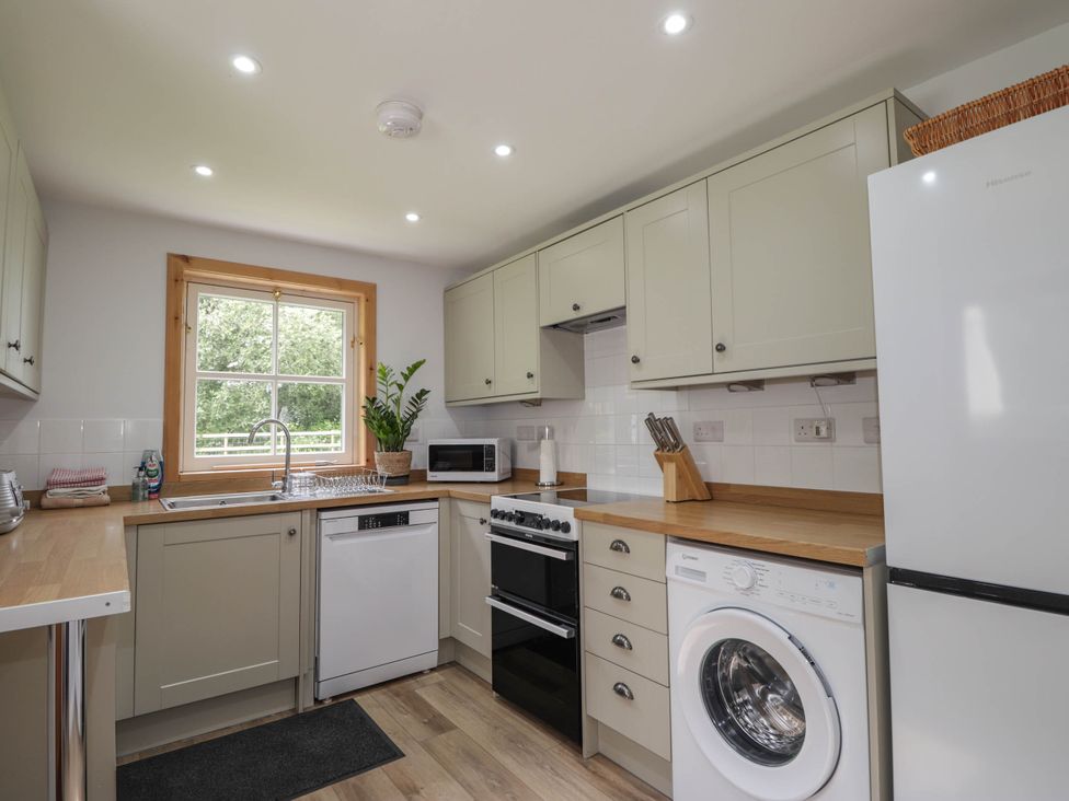 A kitchen with modern appliances and a window at Station Lodge near Forres