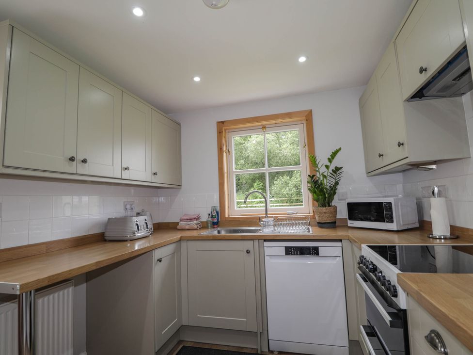 A kitchen with appliances and a window at Station Lodge near Forres
