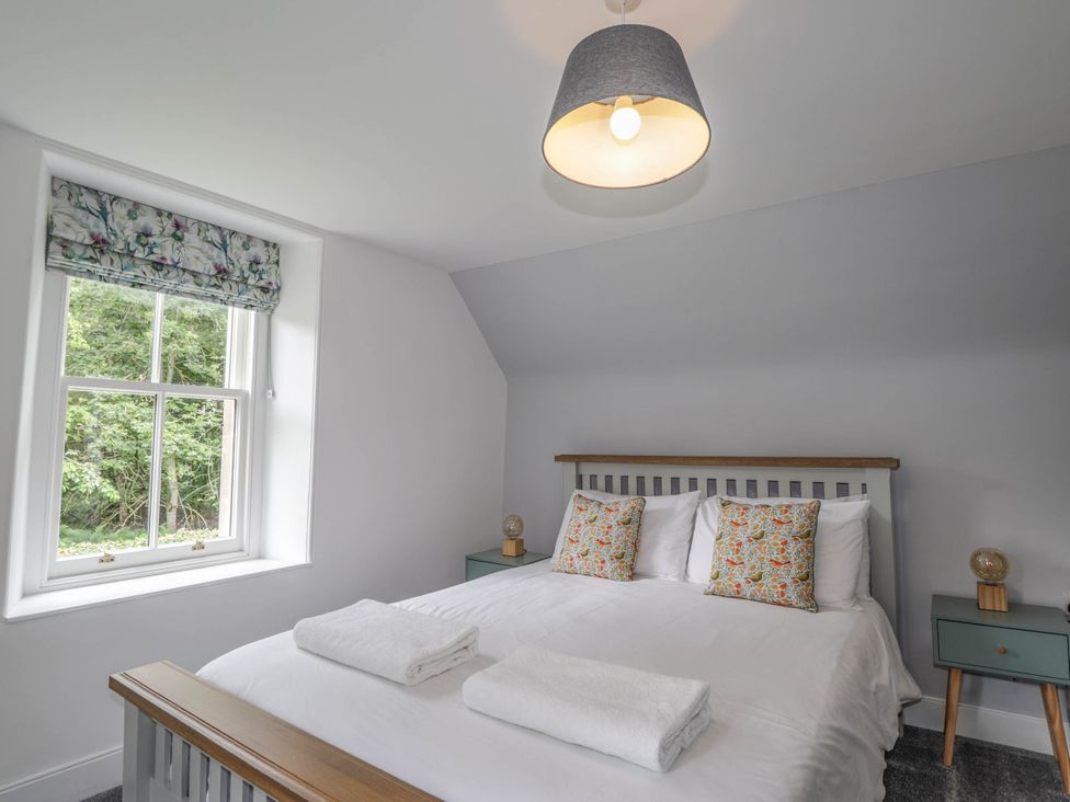 A bedroom with a double bed and window at Station Lodge near Forres