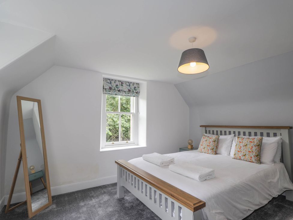 A bedroom with a bed and a mirror at Station Lodge near Forres