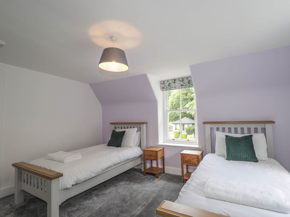 A bedroom with two beds and a window at Station Lodge near Forres