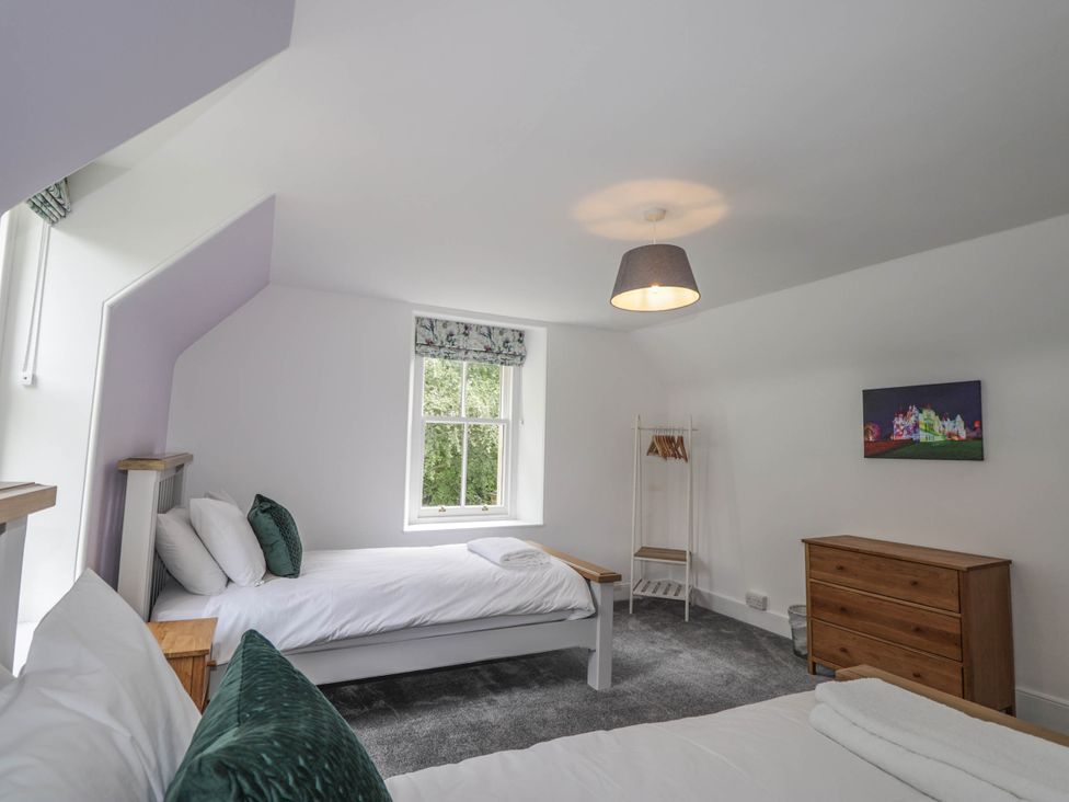 A bedroom with two beds and a dresser at Station Lodge near Forres
