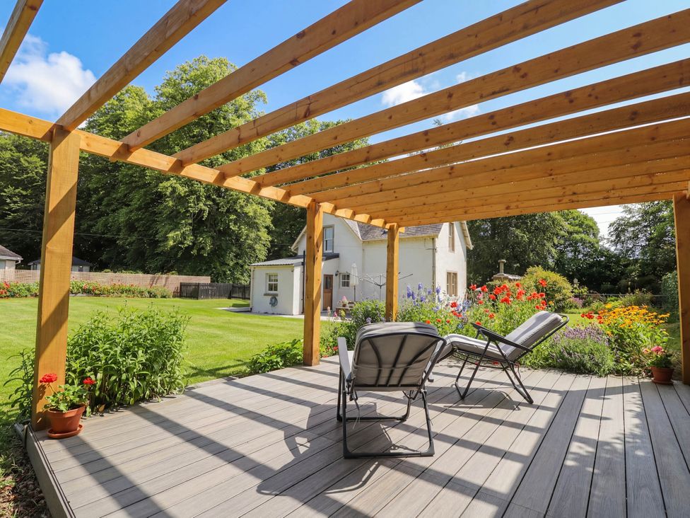 A garden with decking and recliner chairs at Station Lodge near Forres
