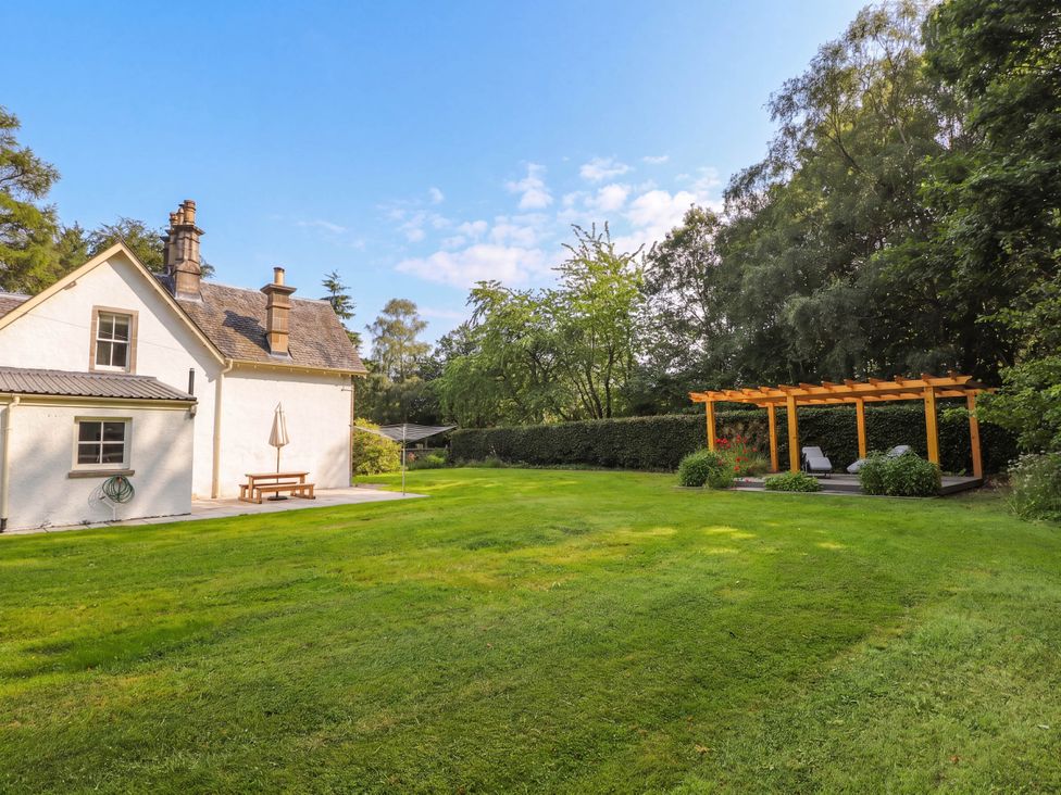 An outdoor space with a house and pergola at Station Lodge near Forres