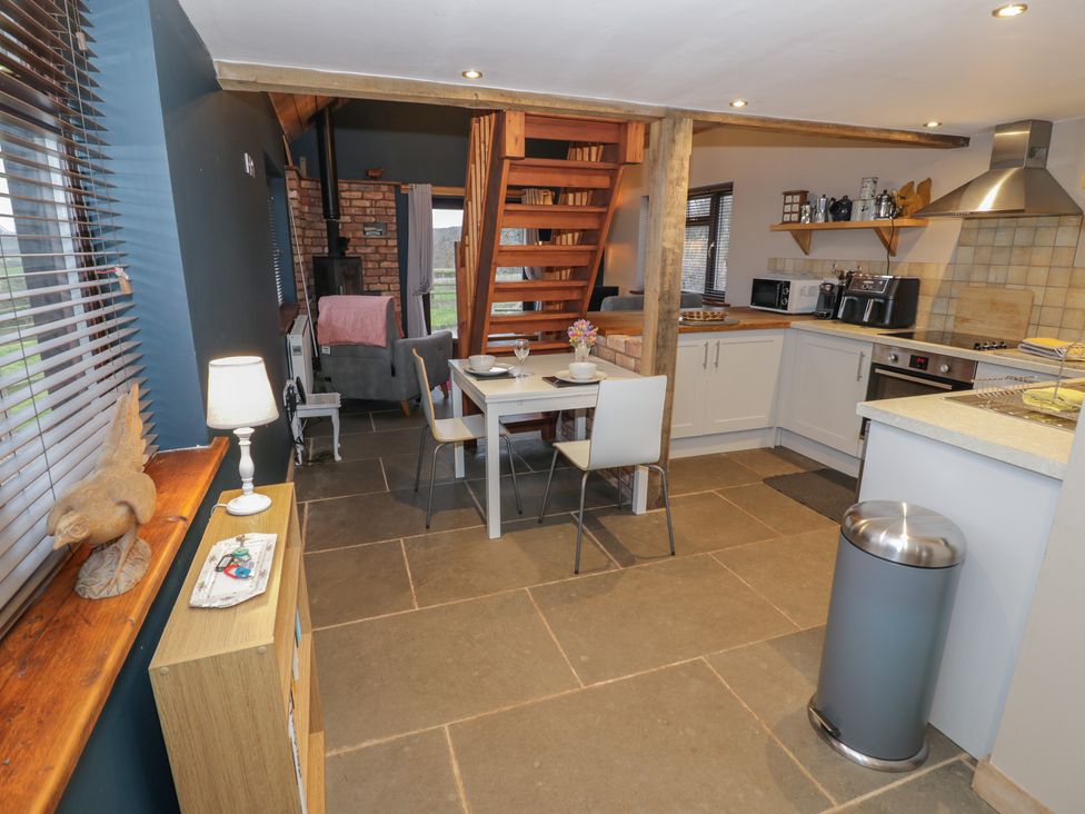 A kitchen with table and chairs at The Barn on The Lagoon Droitwich