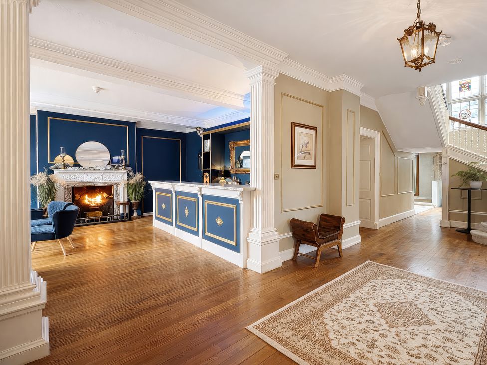 A lobby with a fireplace and staircase at Hanlith Hall near Malham