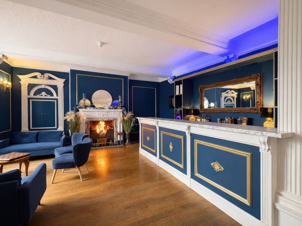 A lounge with a fireplace and a bar at Hanlith Hall in Hanlith near Malham