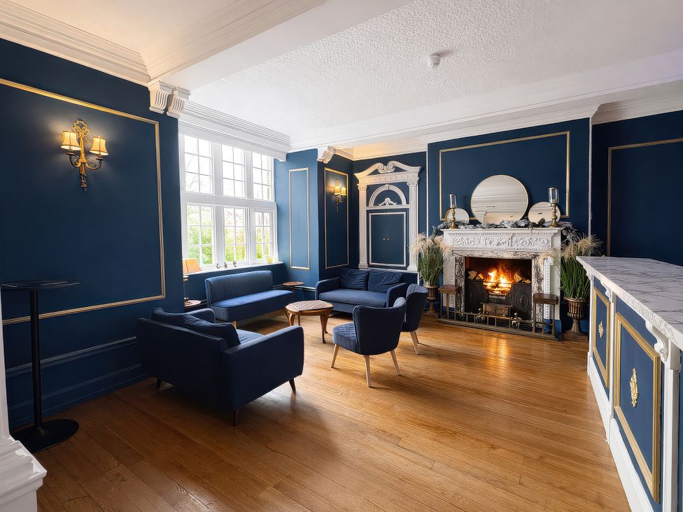 A sitting room with a fireplace and sofas at Hanlith Hall near Malham