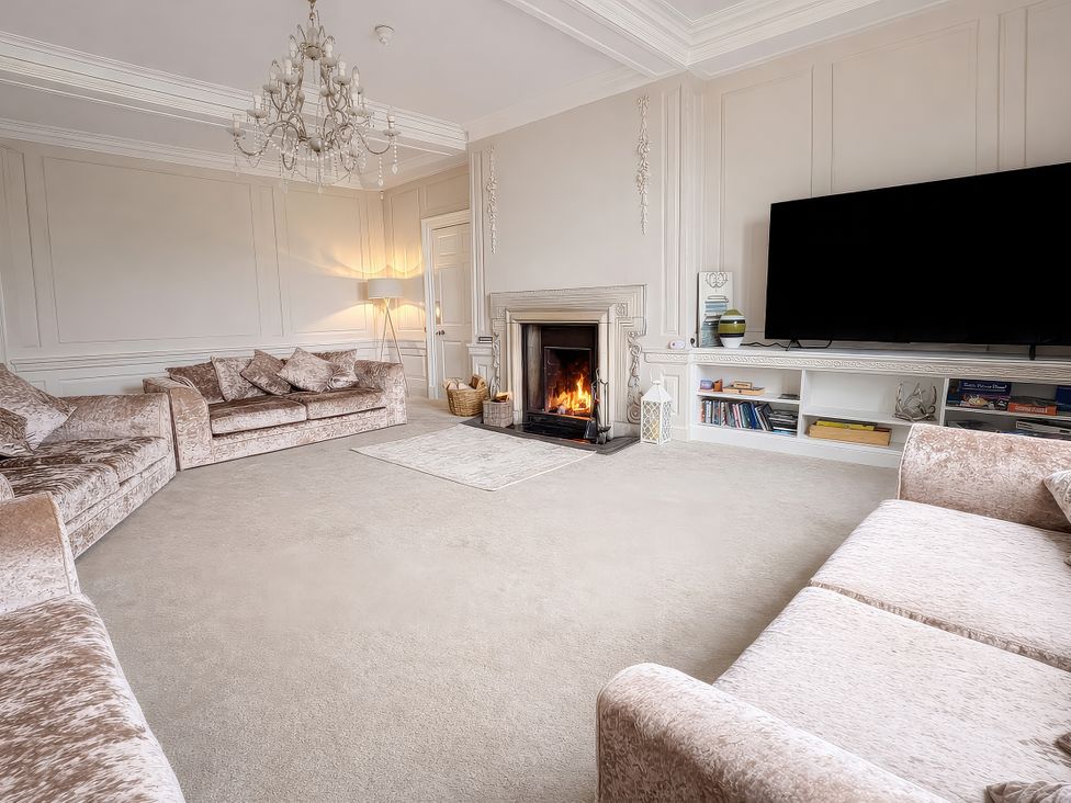 A living room with a fireplace and sofa at Hanlith Hall near Malham