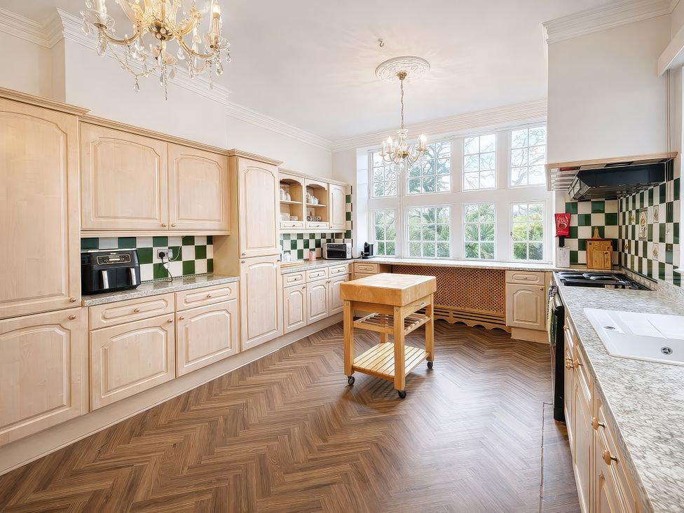 A kitchen with wooden cabinets and a kitchen island at Hanlith Hall near Malham