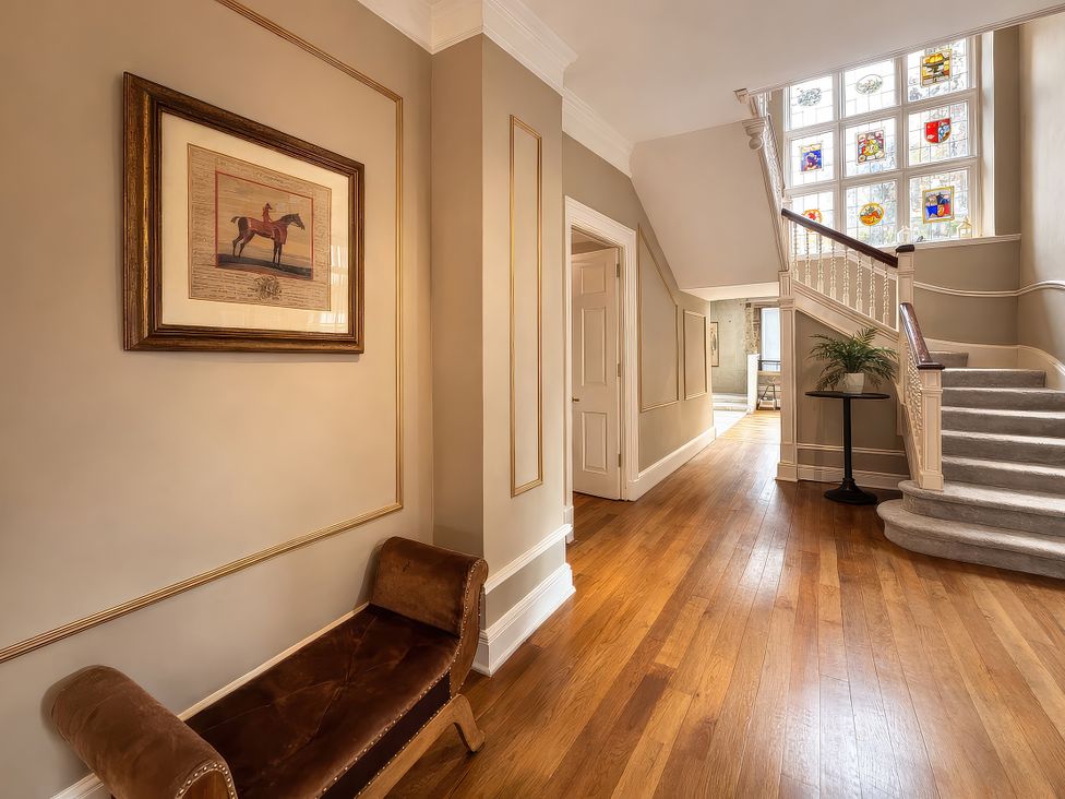 A hallway with a stairs and a painting at Hanlith Hall near Malham