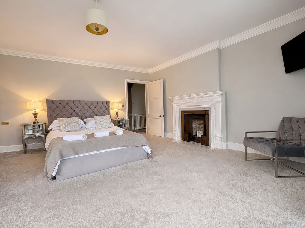 A bedroom with a bed and fireplace at Hanlith Hall near Malham