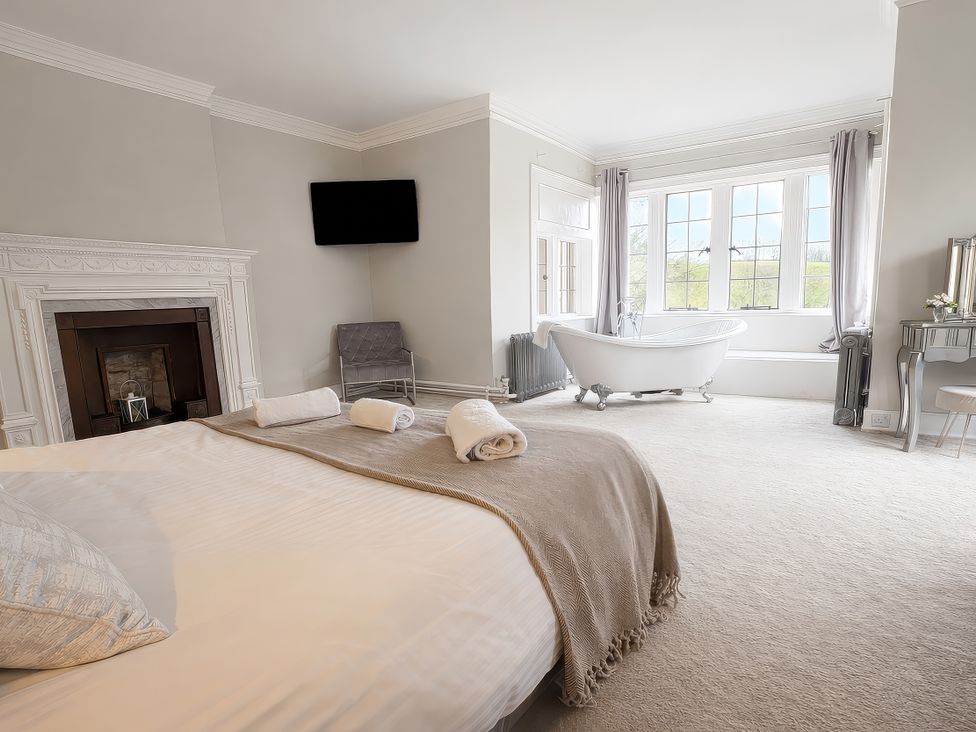 A bedroom with a bed and a bath tub at Hanlith Hall near Malham