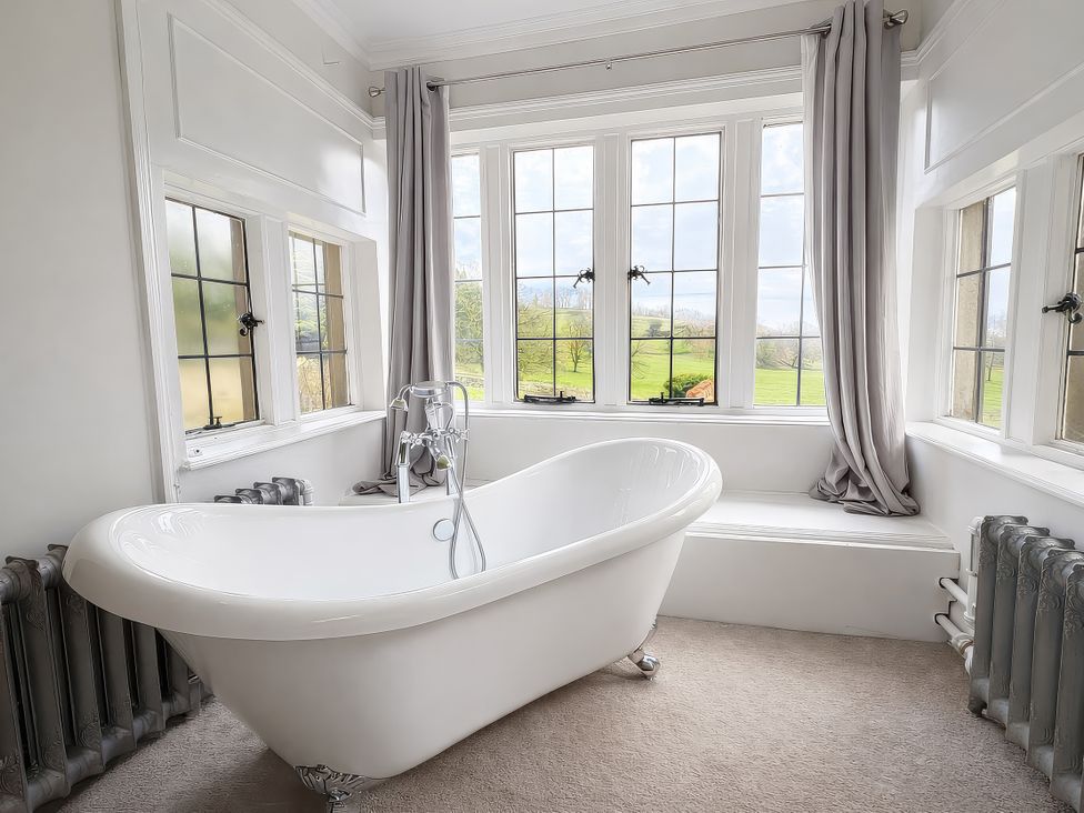 A bathroom with a bathtub and window at Hanlith Hall near Malham