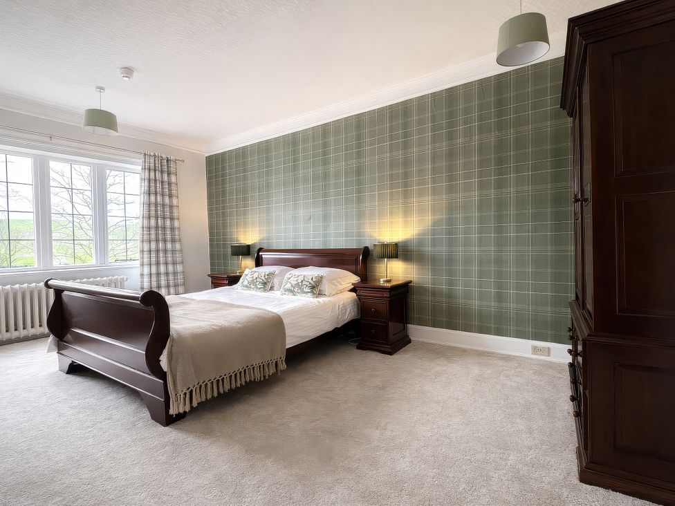 A bedroom with a bed and wardrobe at Hanlith Hall near Malham