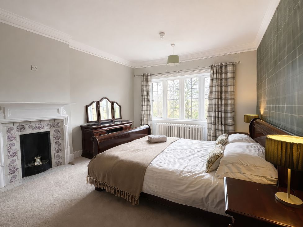 A bedroom with a bed and a wardrobe at Hanlith Hall in Hanlith near Malham