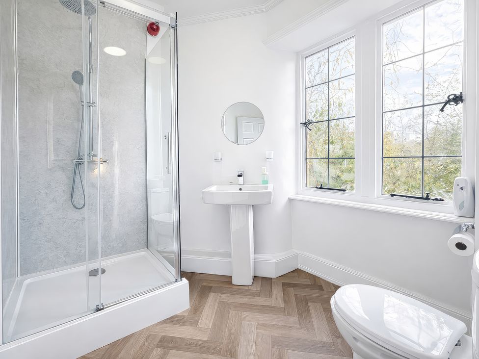 A bathroom with a shower, sink, and toilet at Hanlith Hall near Malham