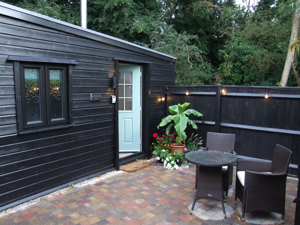 An outdoor area with a door and table at Woodland Lodge The Snug in Filby