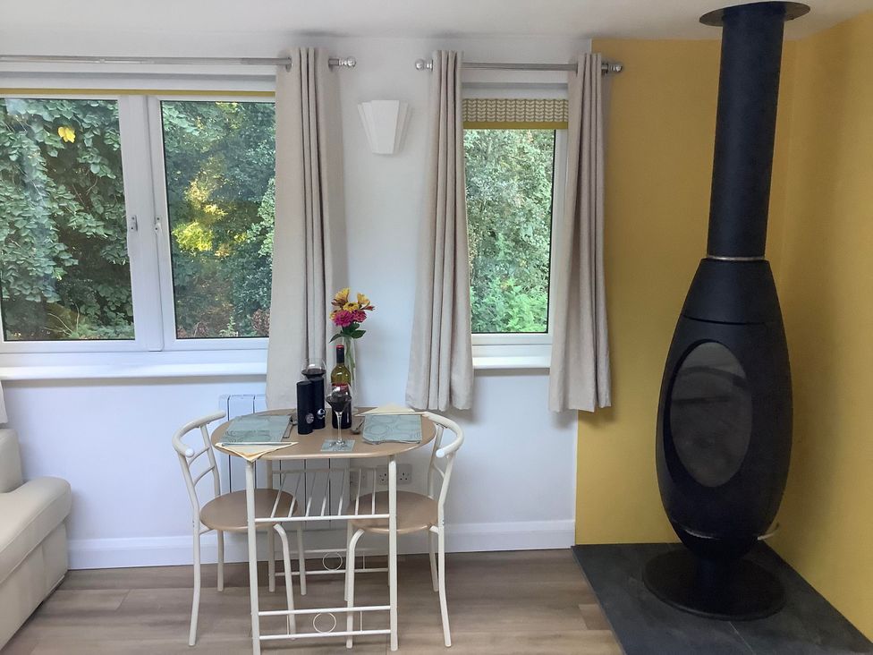 A dining area with a table and chairs at Woodland Lodge The Snug Filby