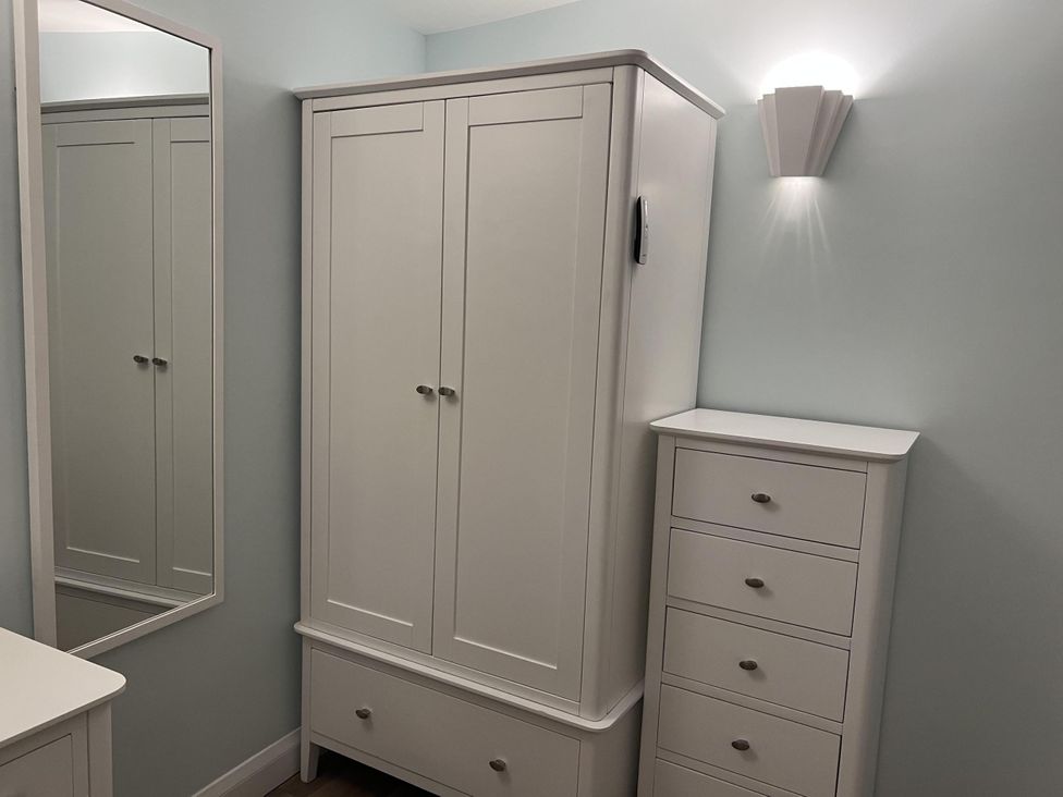 A bedroom with a wardrobe and chest of drawers at Woodland Lodge The Snug Filby