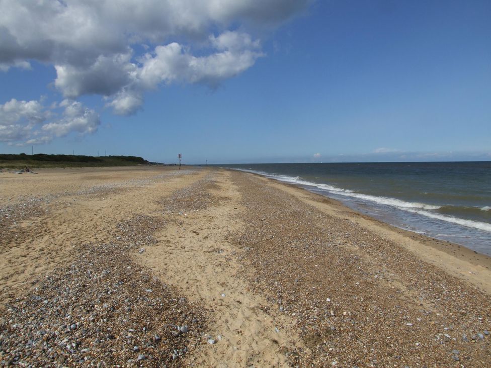 A beach with sand and sea at Woodland Lodge The Snug Filby
