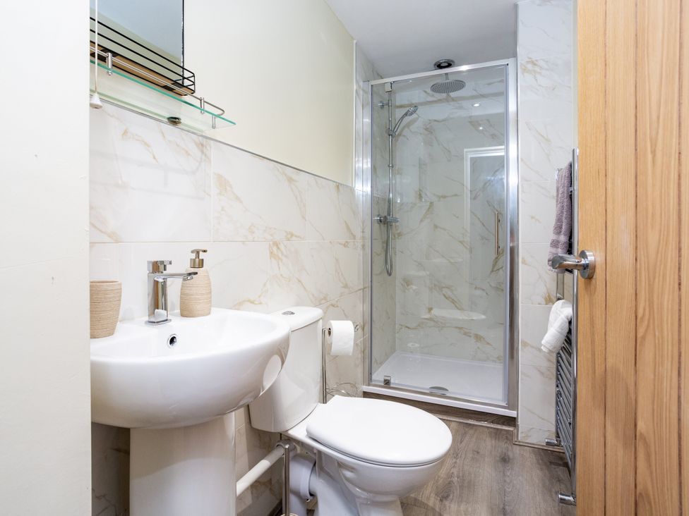 A bathroom with a sink, shower, and toilet at Thieveley Pike View in Burnley