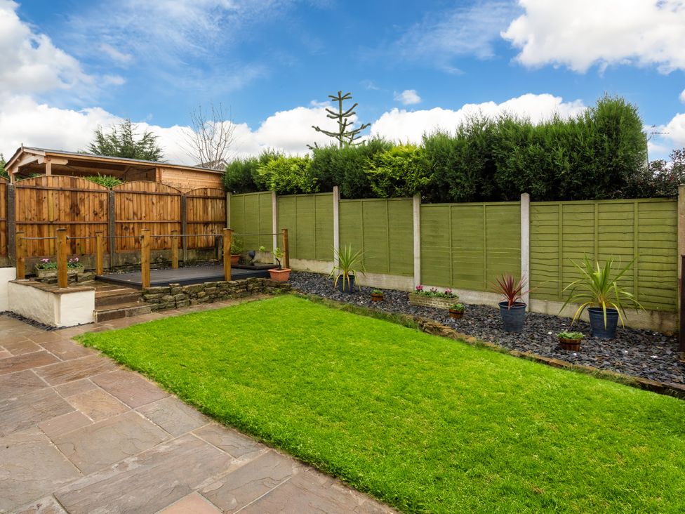 A garden with a lawn and wooden fence at Thieveley Pike View in Burnley