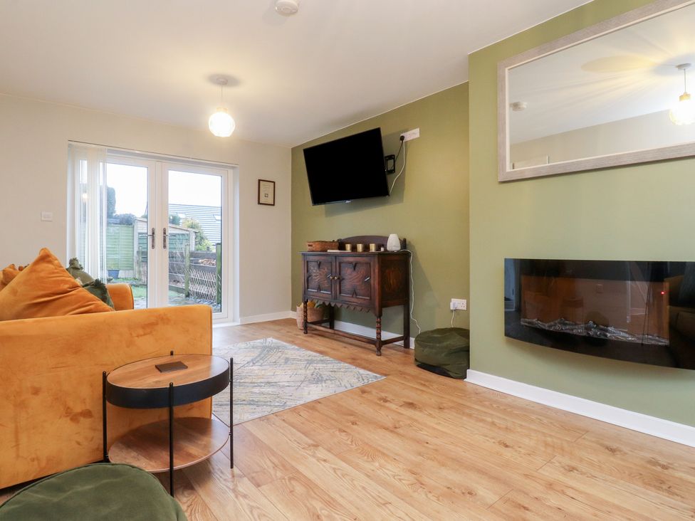 A living room with a sofa and television at Thieveley Pike View in Burnley