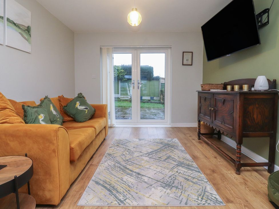 A living room with a sofa and television at Thieveley Pike View in Burnley
