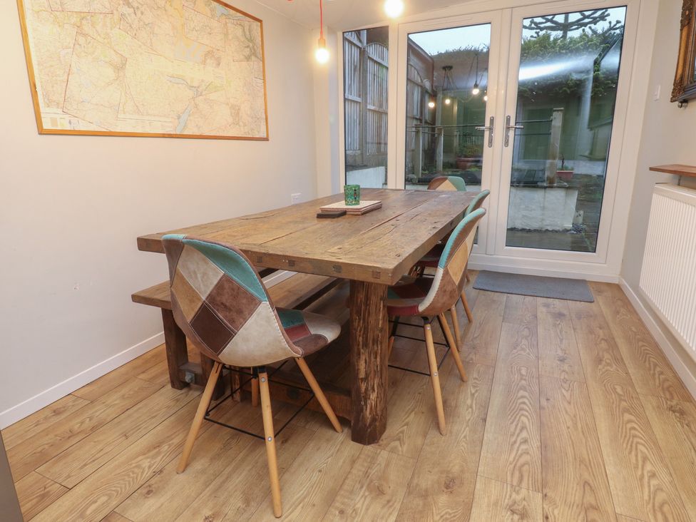 A dining room with a wooden table and chairs at Thieveley Pike View in Burnley