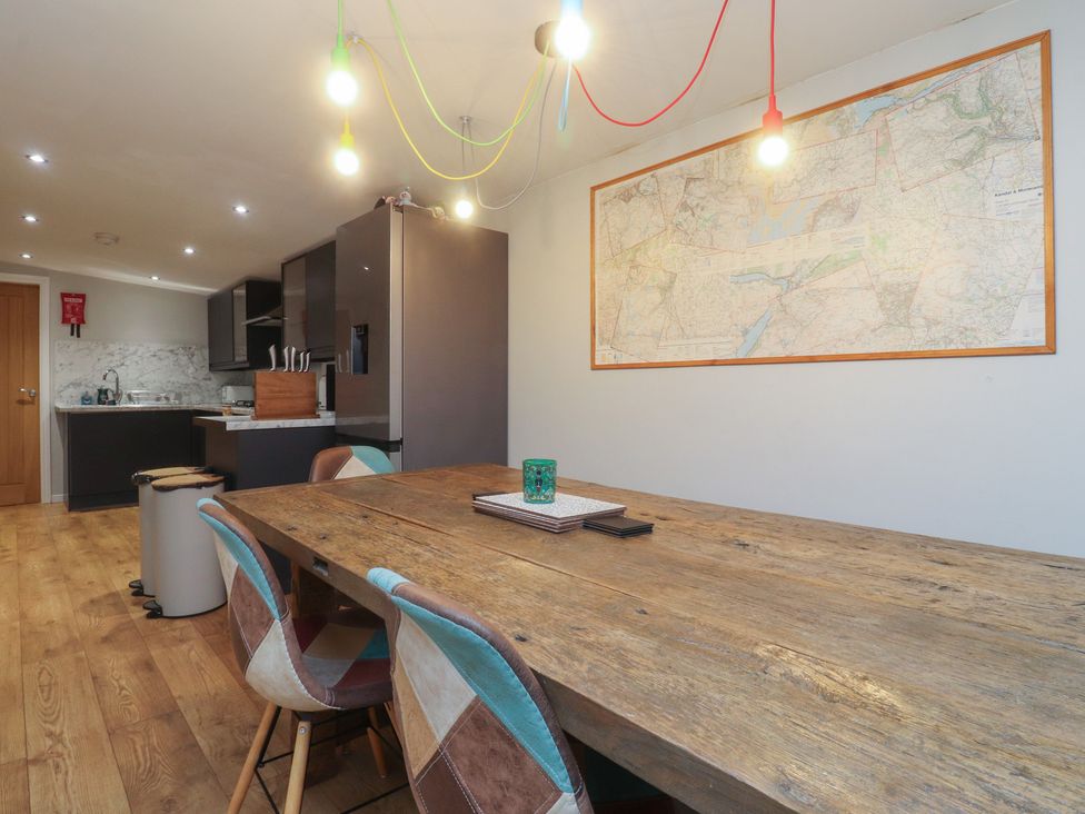 A dining room with a table and chairs and a map on the wall at Thieveley Pike View in Burnley