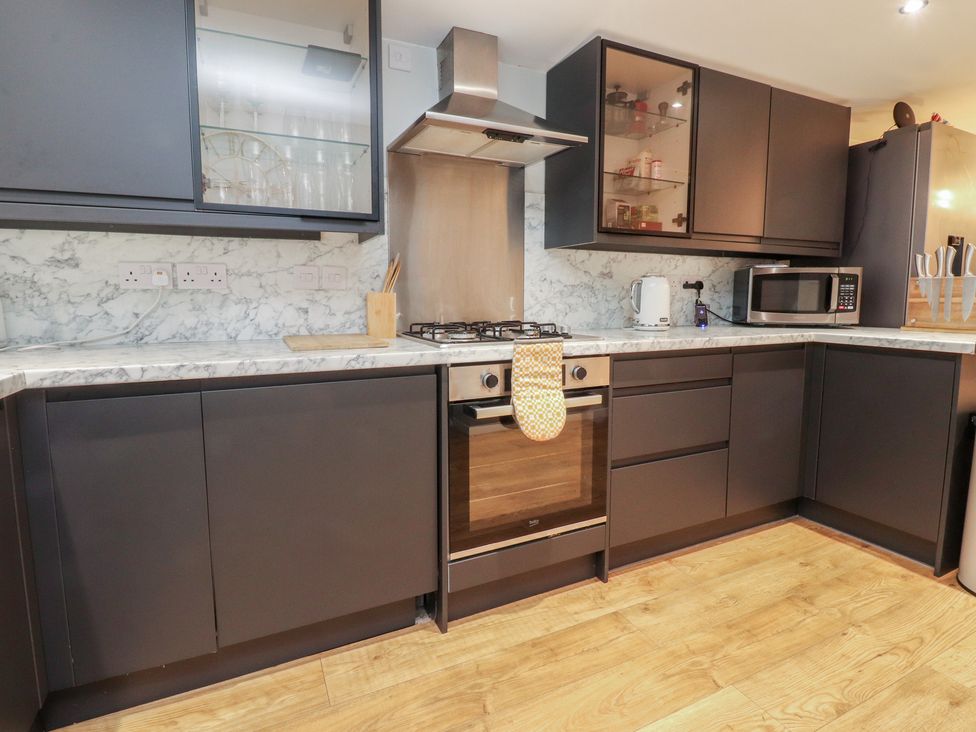 A kitchen with cabinets and appliances at Thieveley Pike View in Burnley
