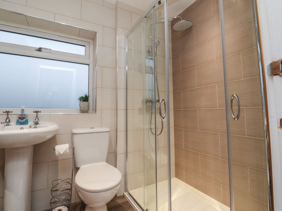 A bathroom with a sink, toilet, and shower at Thieveley Pike View in Burnley